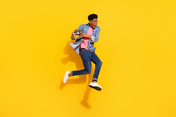 Full size photo happy cheerful dark skin man jump up hold disco ball enjoy isolated on yellow color background