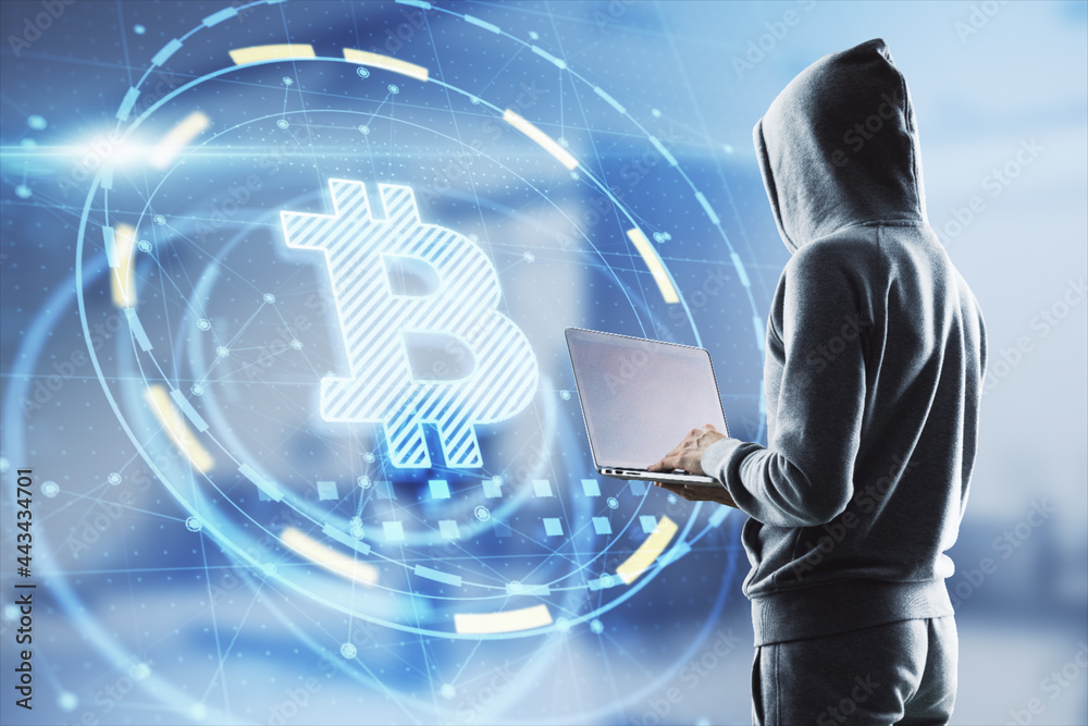 Aufkleber Hacker in hoodie using laptop computer with glowing bitcoin interface in blurry office interior. Hacking, theft and cryptocurrency concept. Double exposure.