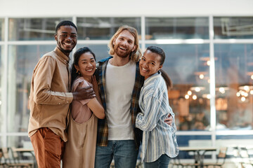 Diverse group of young people posing outdoors in city setting and smiling at camera, copy space