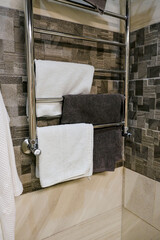 Whitу  and black towel hangs onwall in modern shower bathroom spa hotel with tiles on the wall after washing. Luxury modern interior inside of the spa bathroom