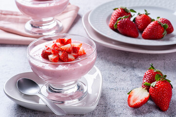 Delicious strawberry mousse in glass bowl with fresh strawberries.