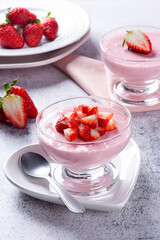 Delicious strawberry mousse in glass bowl with fresh strawberries.