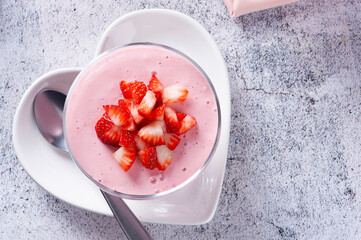 Delicious strawberry mousse in glass bowl with fresh strawberries. Top view. Copy space