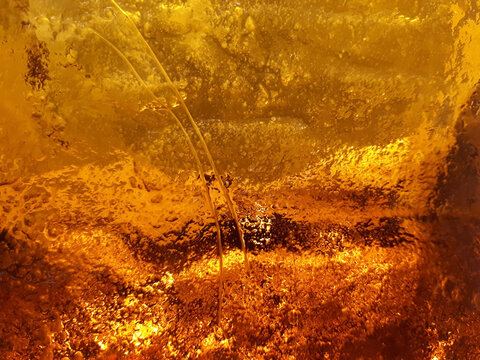 Thick glass of beautiful amber-orange color close-up