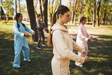 Female in creme hoodie focused on tai chi activity