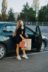 Shopping, sale, Happy young stylish blonde woman with shopping bags opening car after shopping. Girl is putting shopping bags into car