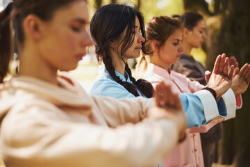 Tai chi greeting performed by women on outdoor training - obrazy, fototapety, plakaty