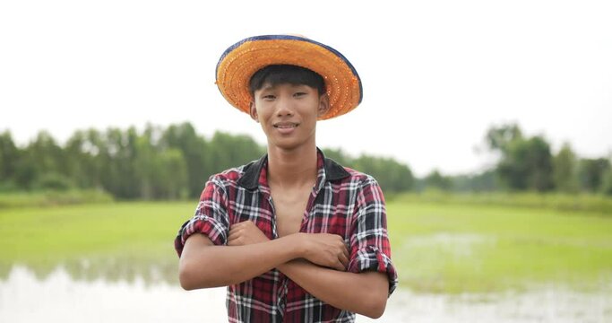 Portrait Young farmer standing and arms folded in rice field