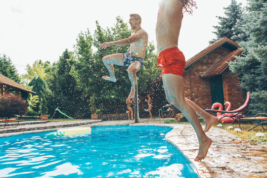 Friends jumping into the swimming pool.Having fun and refreshing on hot on summer day.	