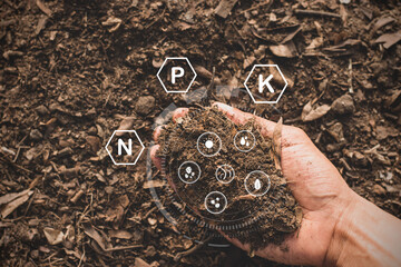 Fertile soil in a man's hand and technology icons all around.