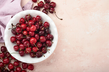 Cherry with water drops on white bowl on pink stone table. Fresh ripe cherries. Sweet red cherries. Top view. Rustic style. Fruit Background