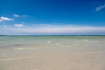 Fototapeta na wymiar Blue sky with clear water and sailboards away from the coast