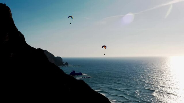 Aerial view of paraglide activity near ocean coastline in Portugal. 