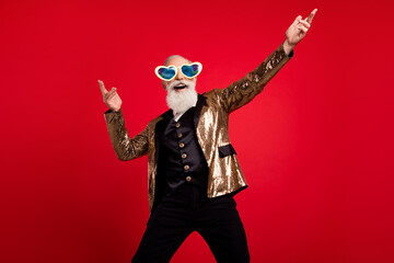 Photo of positive young man dance good mood wear sunlgass entertainer circus isolated on red color background © deagreez