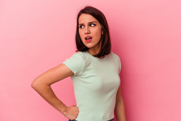 Young caucasian woman isolated on pink background suffering a back pain.