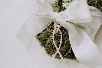 wedding rings tied with string in a flower arrangement with a bow