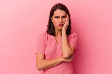 Young caucasian woman isolated on pink background blows cheeks, has tired expression. Facial expression concept.