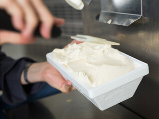 Fototapeta na wymiar creamy ice cream in tray against the background of equipment for making ice cream