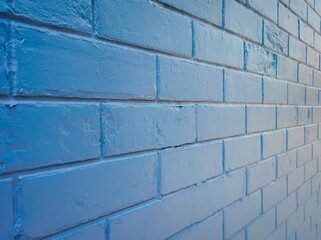 Texture and background of blue brick wall against sunlight.