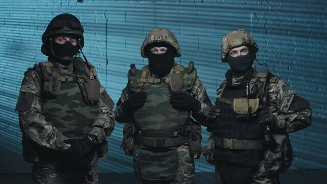 Portrait dolly-in shot of SWAT team in uniform posing for camera while police lights flashing