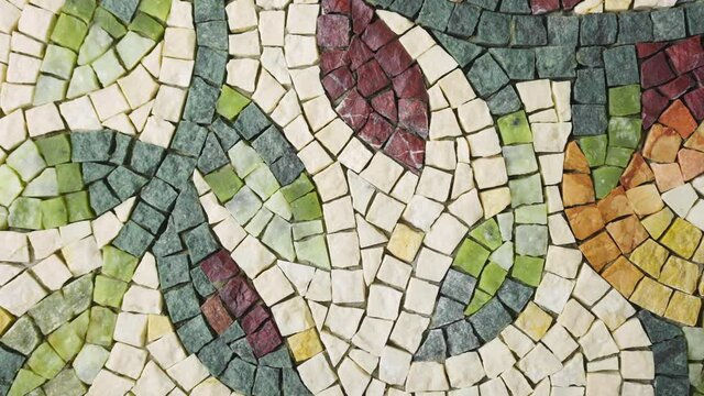 Beautiful mosaic pattern from natural granite stone. Colorful mosaic of small stone tiles in an art studio. The floral pattern is made using the mosaic technique. Close up. Slow motion ready 59.94fps.