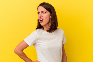 Young caucasian woman isolated on yellow background suffering a back pain.