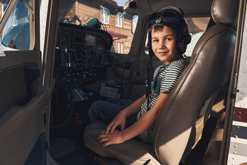 Adorable boy pilot sitting inside plane cockpit © Svitlana