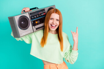 Photo of funky horned lady dressed green outfit smiling holding boombox showing hard rock sign...