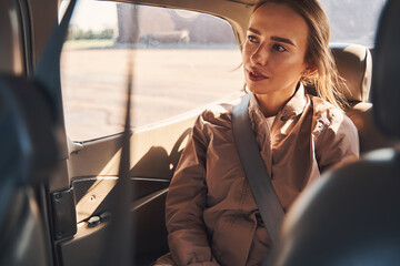 Fototapeta na wymiar Beautiful young woman sitting on passenger seat in vehicle