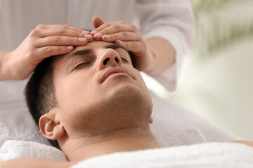 Obraz na płótnie Canvas Man receiving facial massage in beauty salon