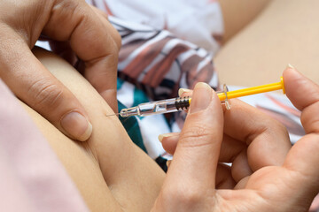 Detail of a woman who injects a dose of heparin into her belly