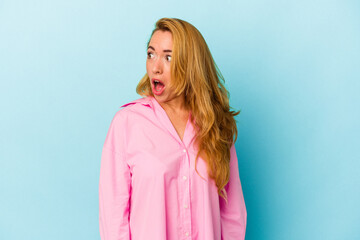 Caucasian woman isolated on blue background being shocked because of something she has seen.