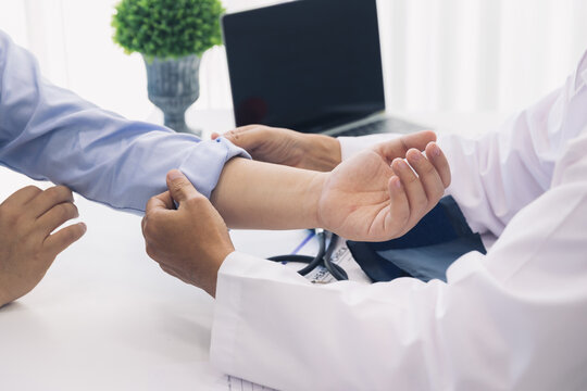 The Doctor Rolls Up The Patient's Sleeve To Measure Blood Pressure Or Give An Injection.