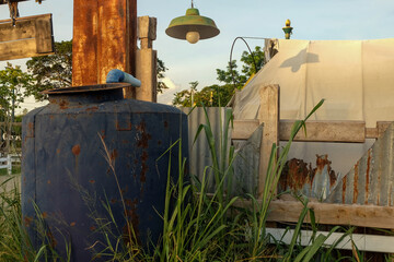 The old water tank was abandoned in the grass.