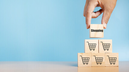 Wood cube stacking with shopping text and shopping cart symbol. E-marketing.