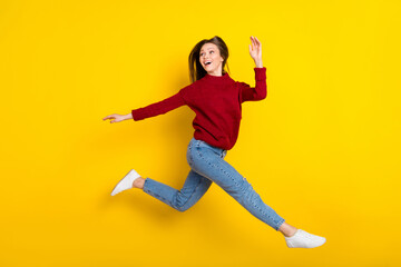 Fototapeta na wymiar Full length profile side photo of young excited woman happy positive smile jump up curious look empty space isolated over yellow color background