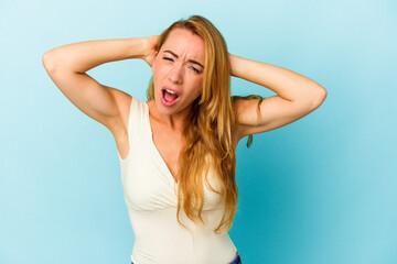 Caucasian woman isolated on blue background screaming, very excited, passionate, satisfied with something.