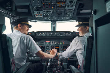 Two professional aviators sitting in the cockpit during the take-off - obrazy, fototapety, plakaty