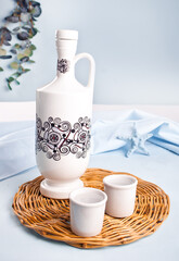 Traditional greek ouzo alcoholic drink anice raki in shot with bottle nearby.