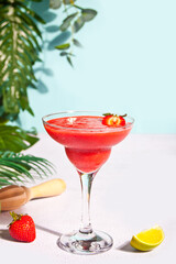 Cold strawberry margarita or daiquiri cocktail with lime and rum