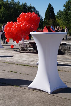 wei&szlig;er Stehtisch mit roten Ballons Abschlussfeier