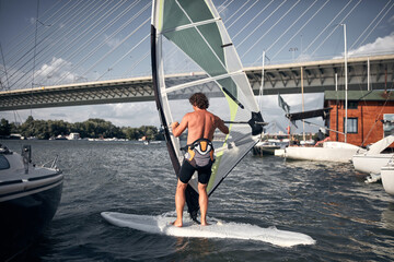 Naklejka premium Windsurfer surfing on a windy day at the river.
