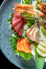 Assorted sashimi of salmon, shrimp, tuna, octopus, scallop and eel. Classic Japanese cuisine. Food delivery. Isolated on black