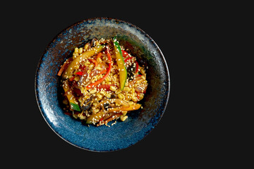 Delicious street food rice wok with vegetables and peanuts in a plate. Classic Asian cuisine. Food delivery. Isolated on black