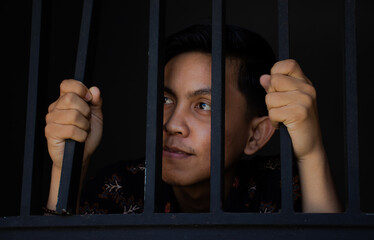 expression of man holding bars in prison