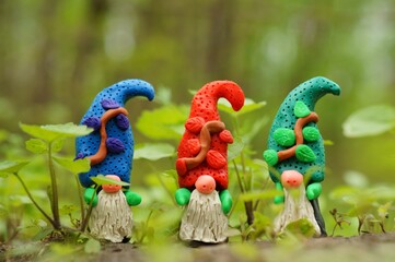 Figurines of three colorful dwarfs made of plasticine.
