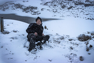 Fototapeta na wymiar young man enjoying snow fall at himalayan mountains at morning