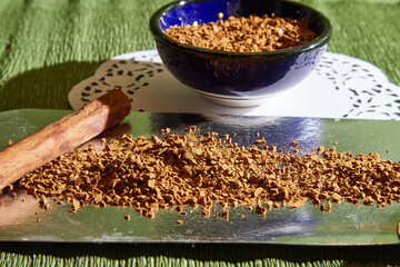 Loose instant coffee in blue beautiful ceramic saucer. A resource for making a delicious coffee drink