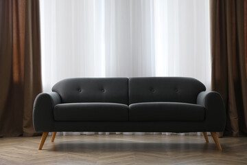 Comfortable grey sofa near window indoors. Interior design