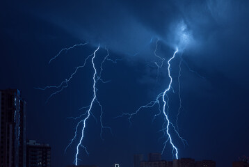 Thunderstorm. Lightning in the night blue sky over the city